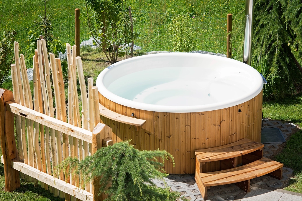 Wooden hot tub in a backyard garden